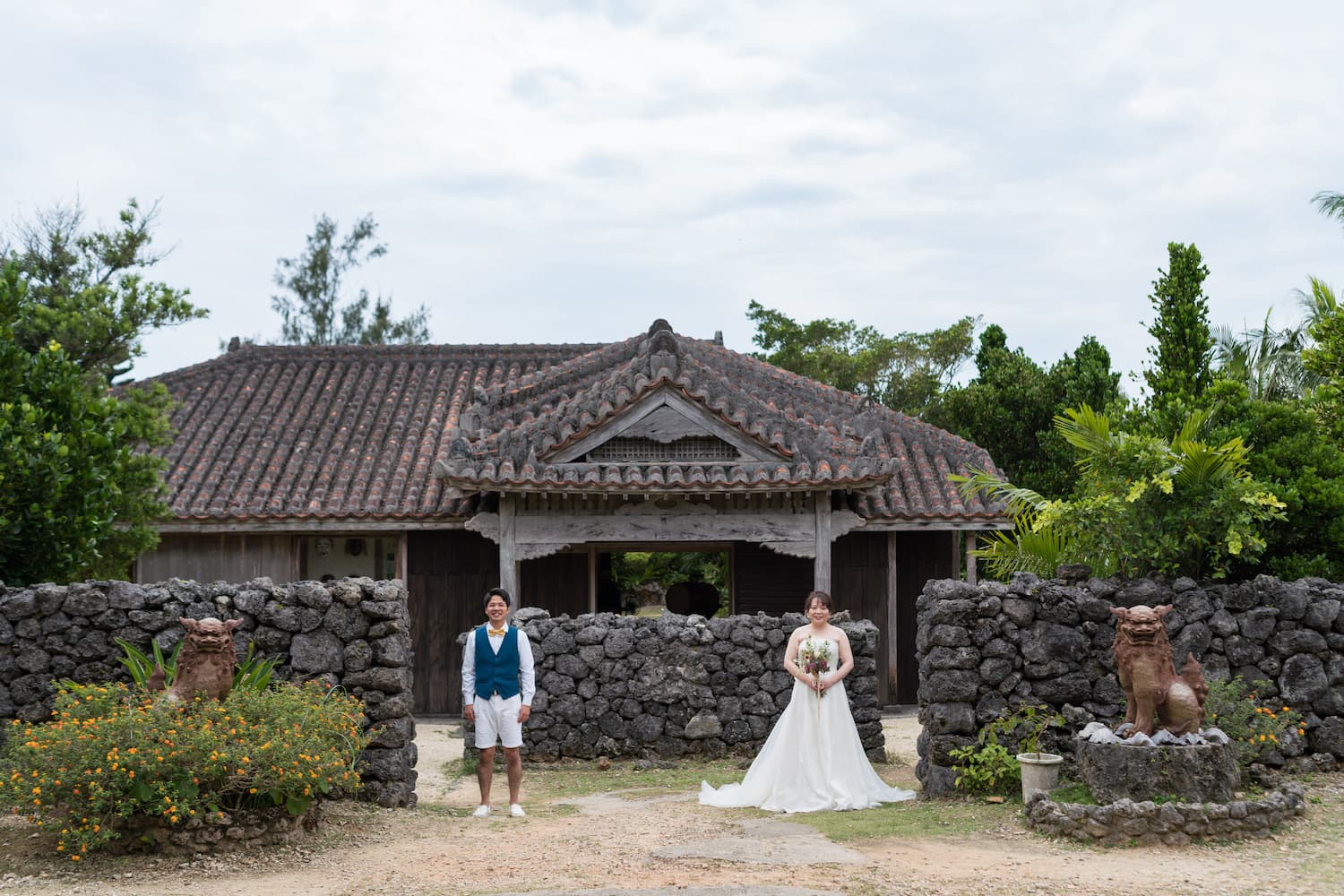 やいま村にある古民家の前で立つ新郎新婦