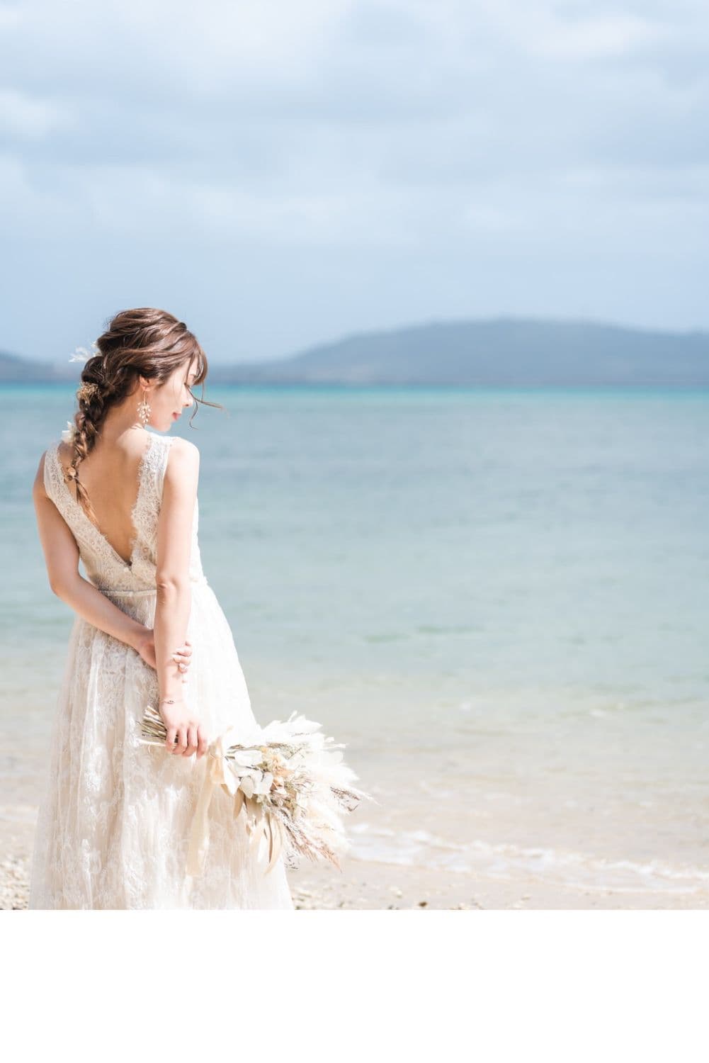 石垣島のビーチで海を眺める新婦の後ろ姿