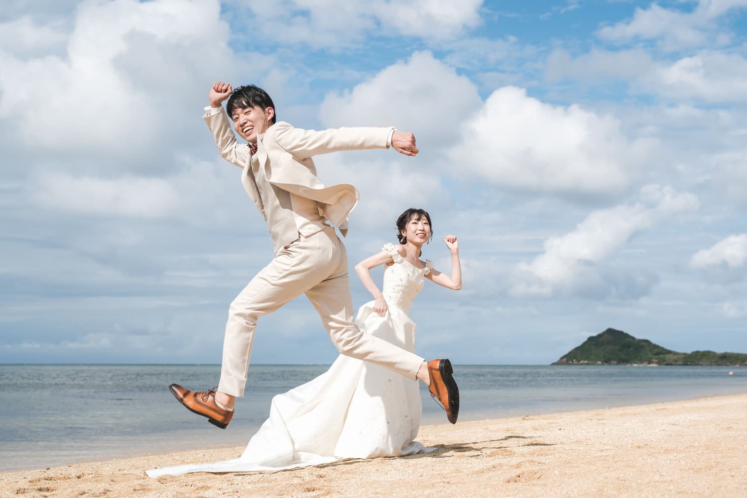 石垣島の海を背景にジャンプする新郎新婦