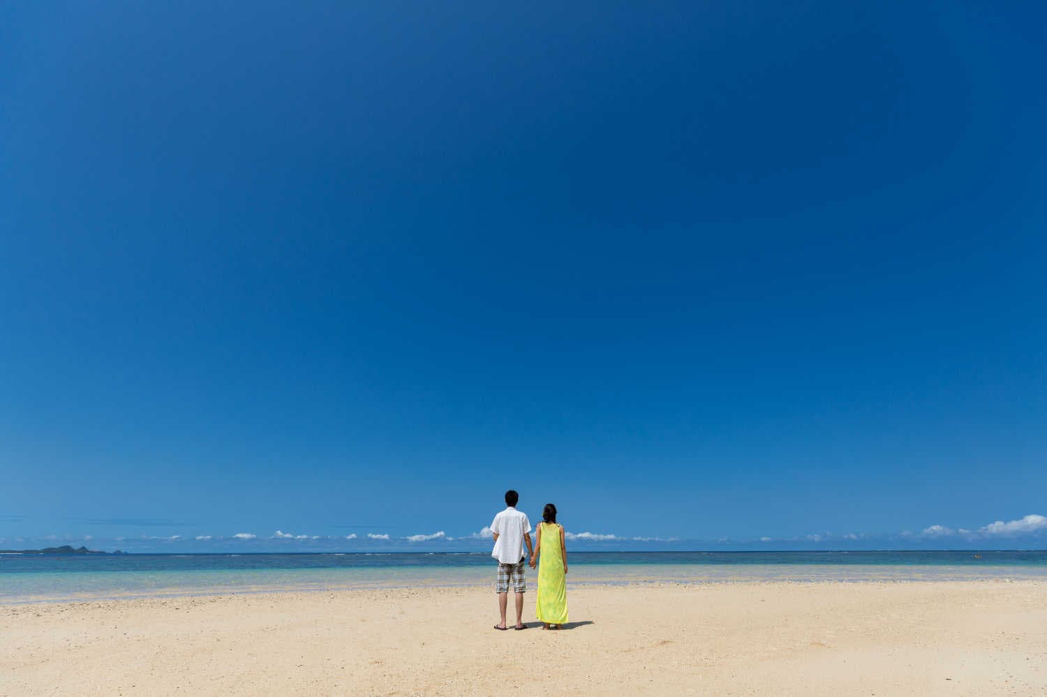 ビーチで海を眺めて立つカップル