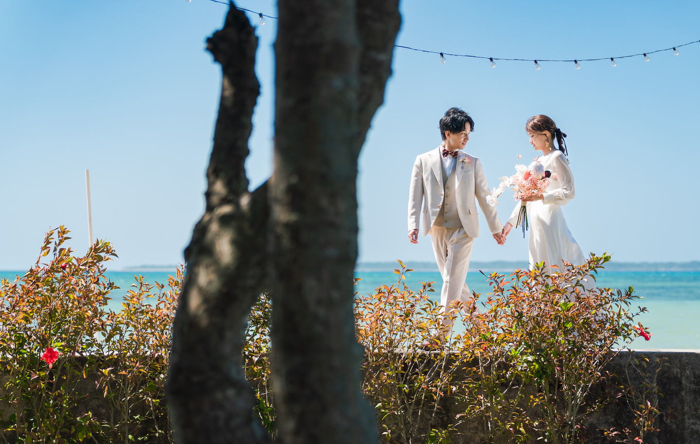 夕焼けに染まる空を背景に新婦へブーケを渡す新郎