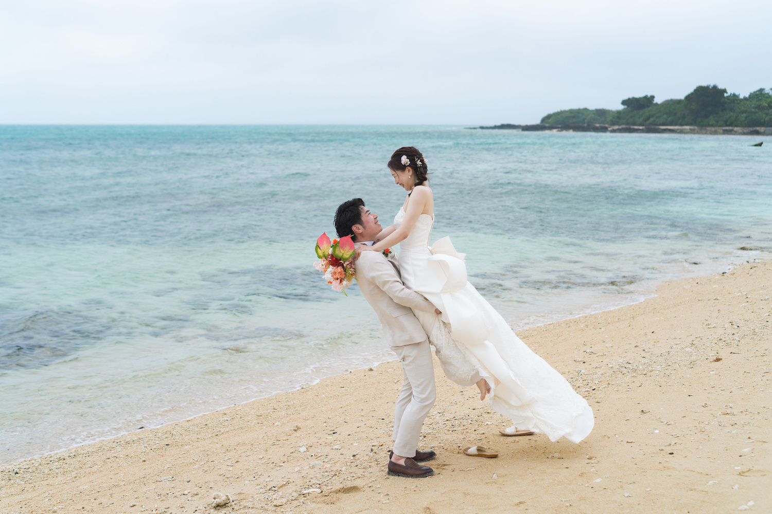 石垣島のビーチで新婦を抱き上げる新郎