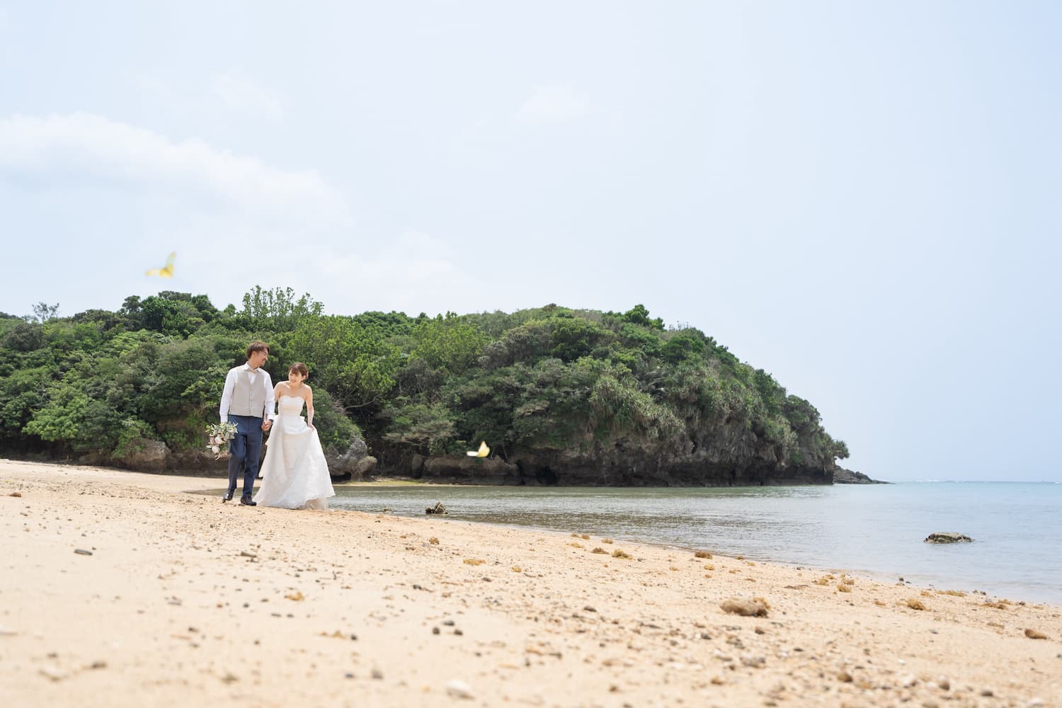 浜辺を歩く新郎新婦