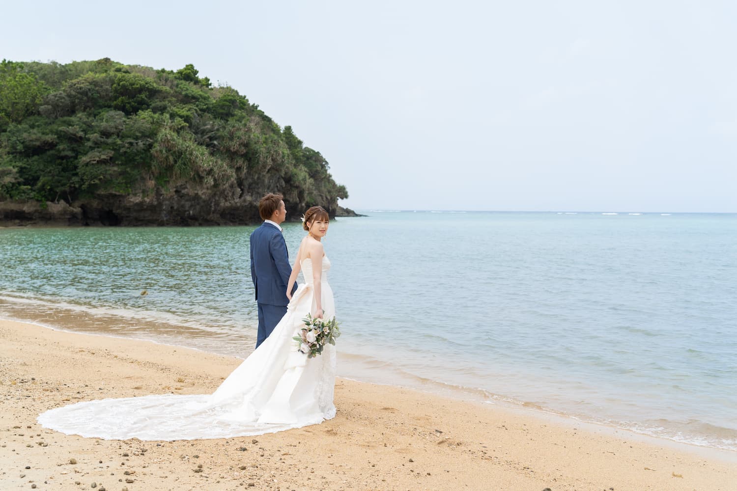 海を背景に立つ新郎新婦