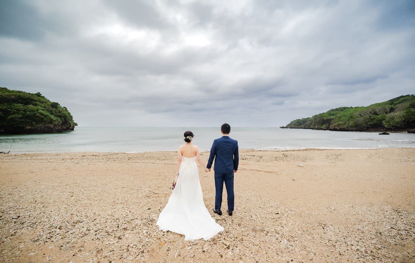 海を眺める新郎新婦の後ろ姿