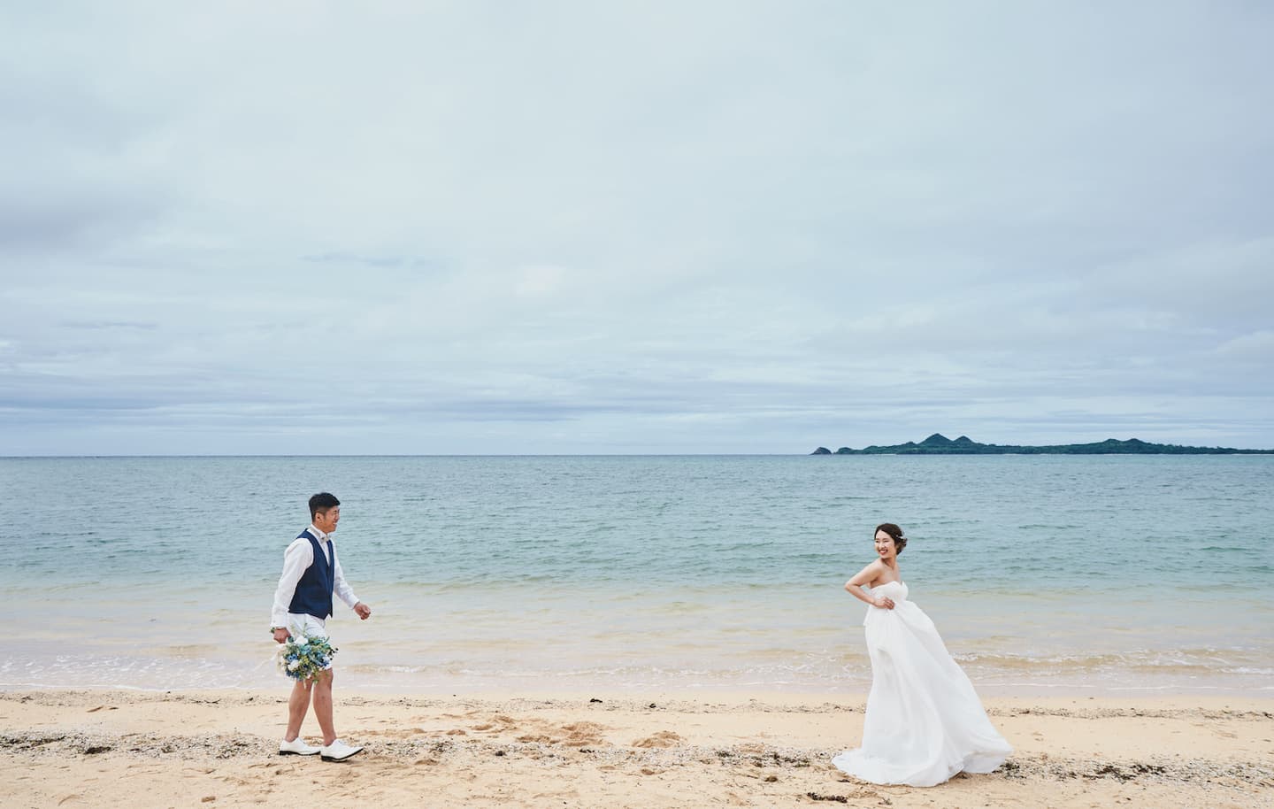 浜辺でお互いに歩み寄る新郎新婦