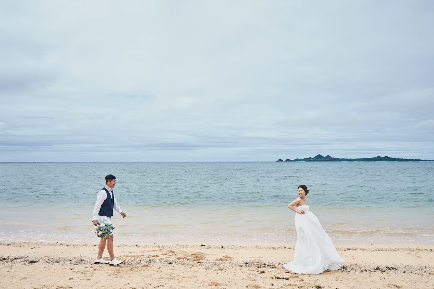 浜辺を歩く新郎新婦