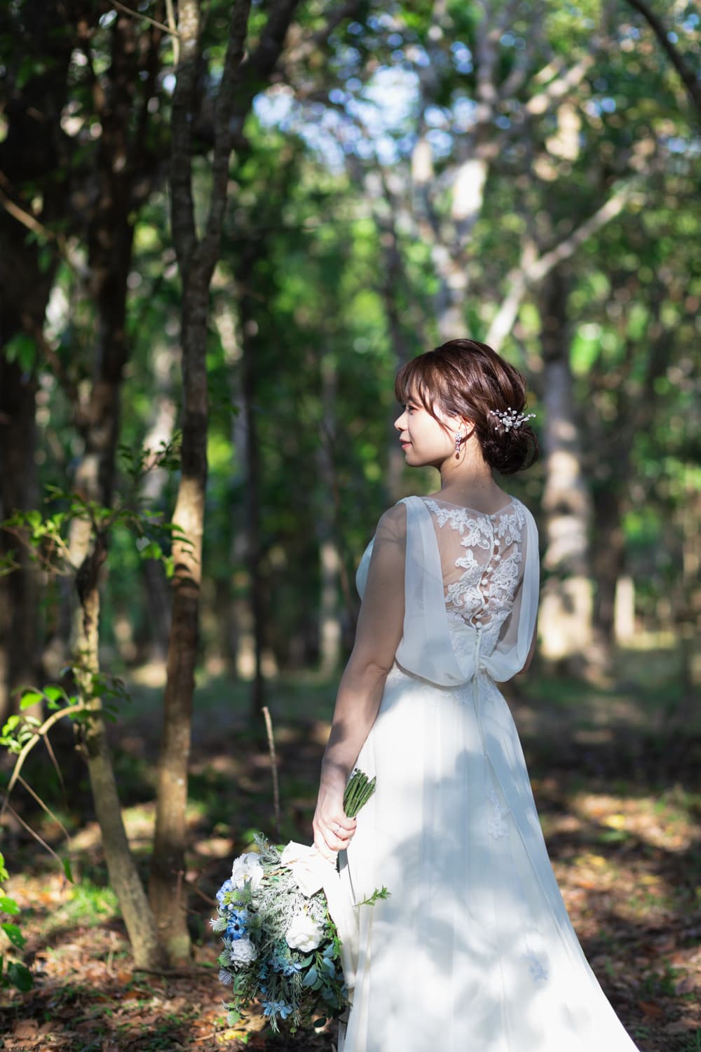 木漏れ日の中に立つ新婦の後ろ姿