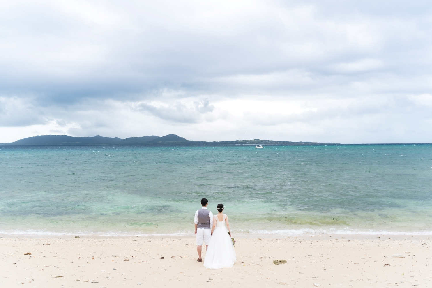 石垣島の青い海を眺める新郎新婦の後ろ姿