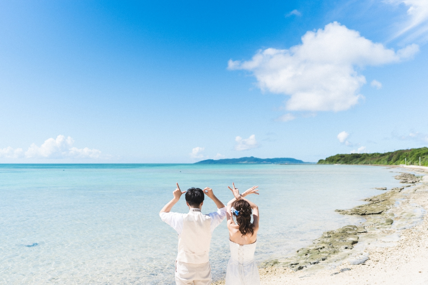 竹富島の海を眺める新郎新婦の後ろ姿