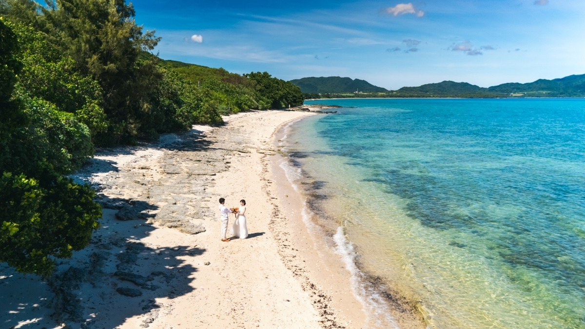 石垣島の海で見つめ合う新郎新婦のドローン写真