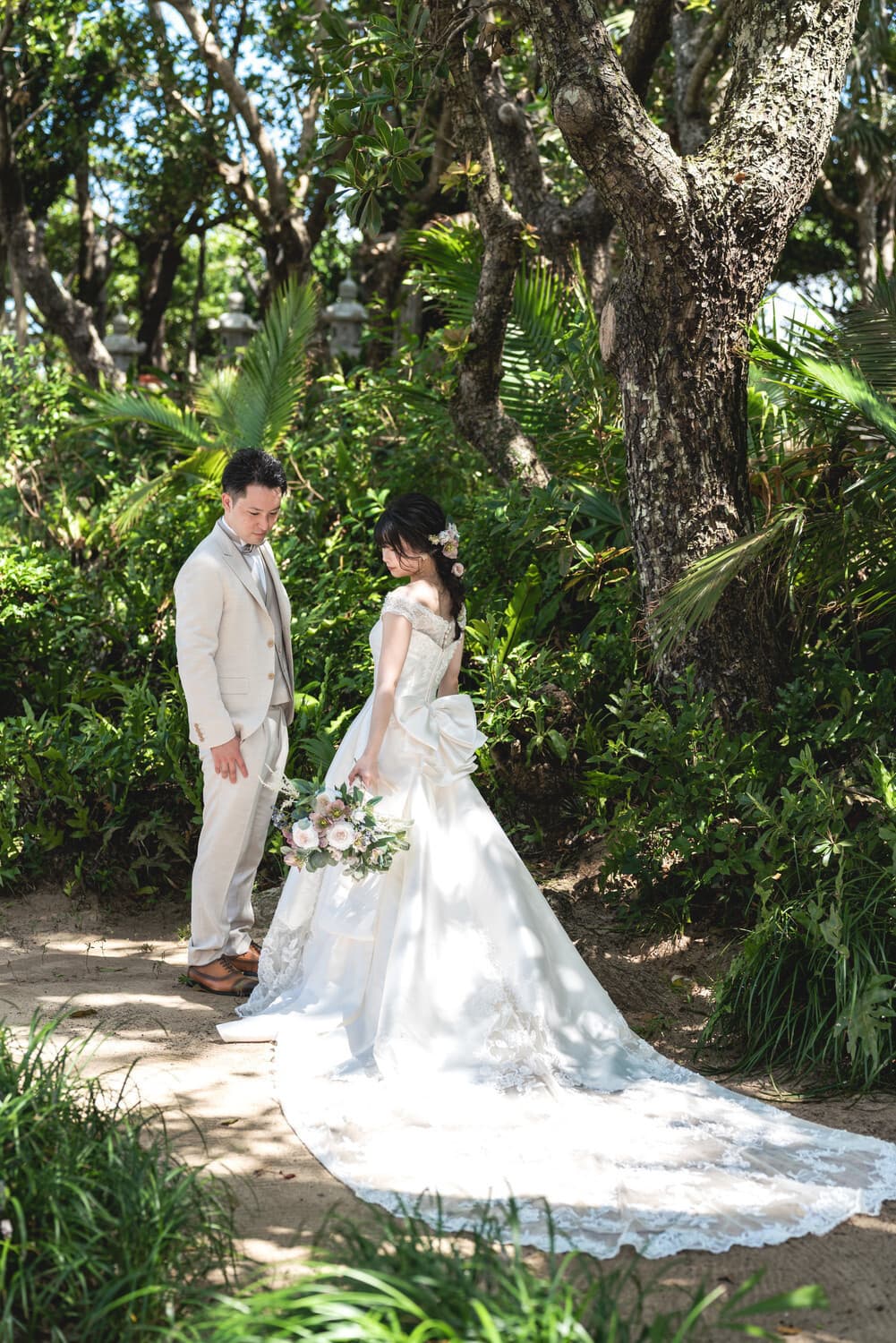 グリーンの中で向かい合わせに立つ新郎新婦