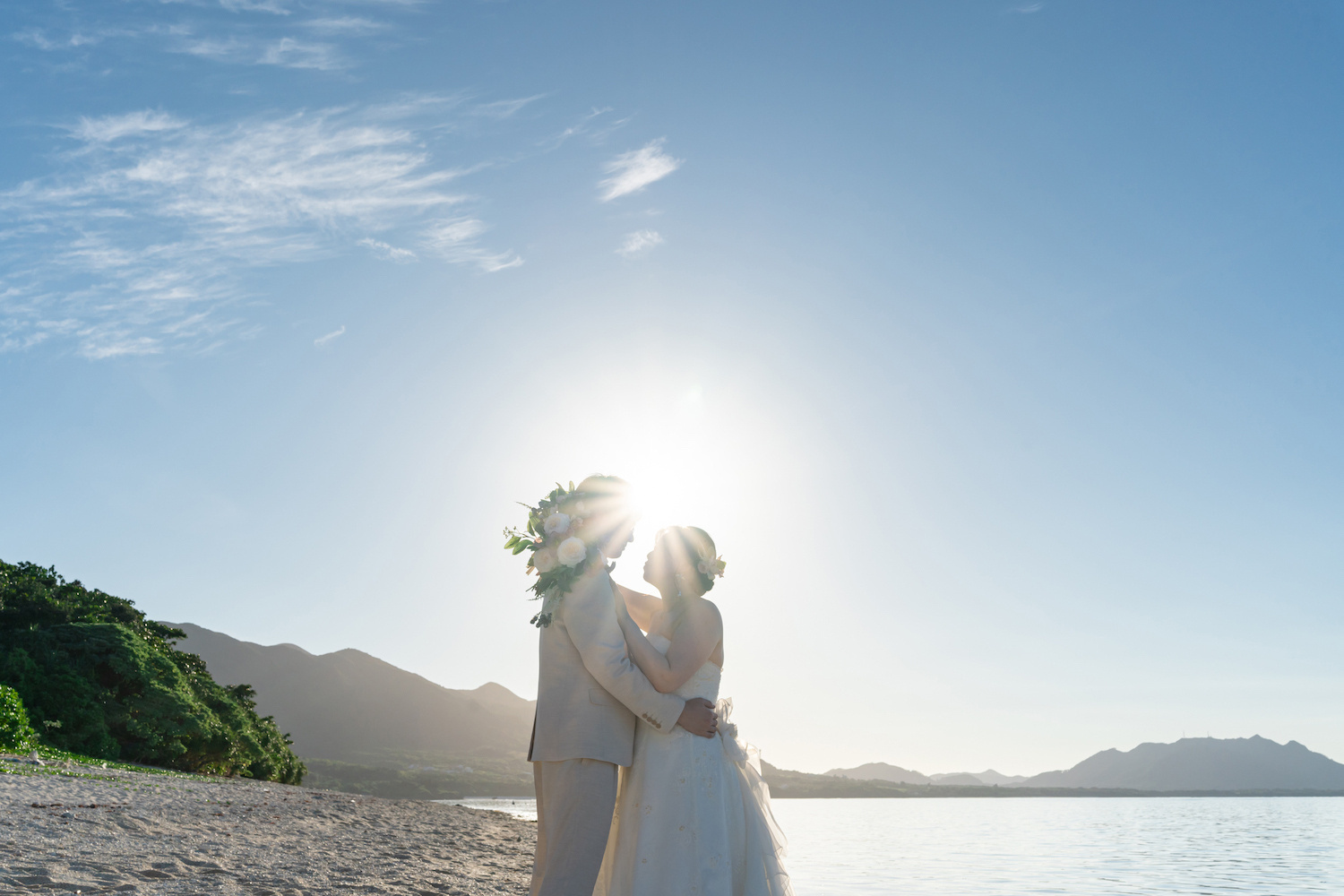 青空を背景に抱き合う新郎新婦