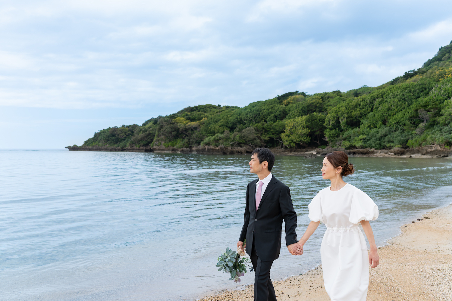 浜辺を歩く新郎新婦