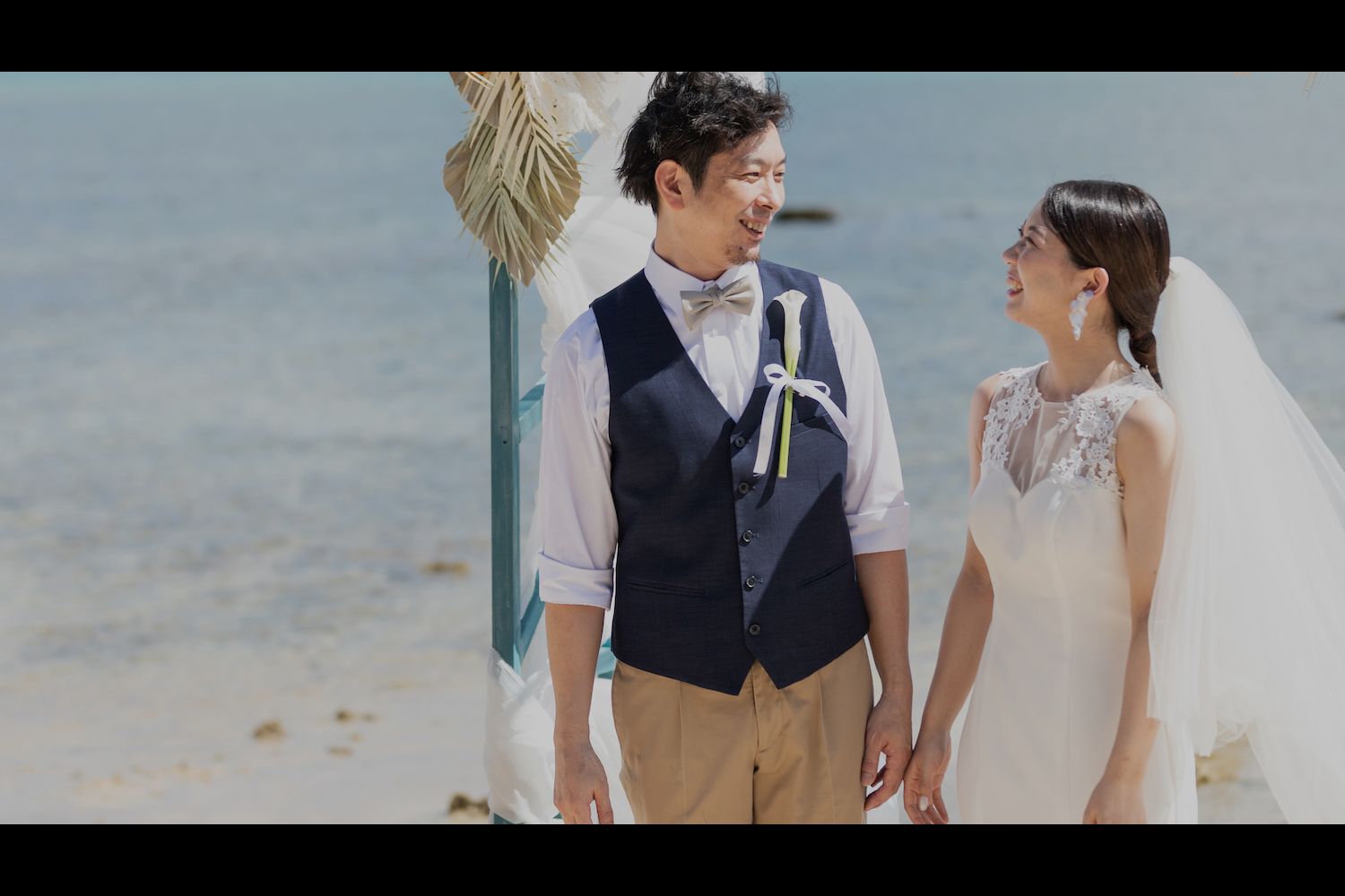 石垣島の海を背景に挙式を行う新郎新婦