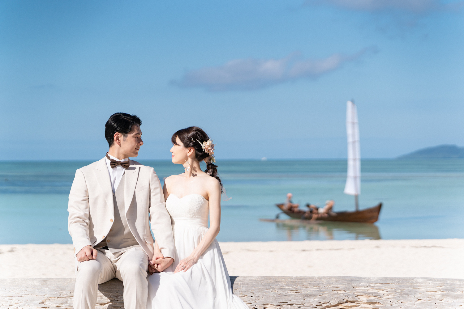 竹富島のコンドイビーチでサバニ船を背景に見つめ合う新郎新婦