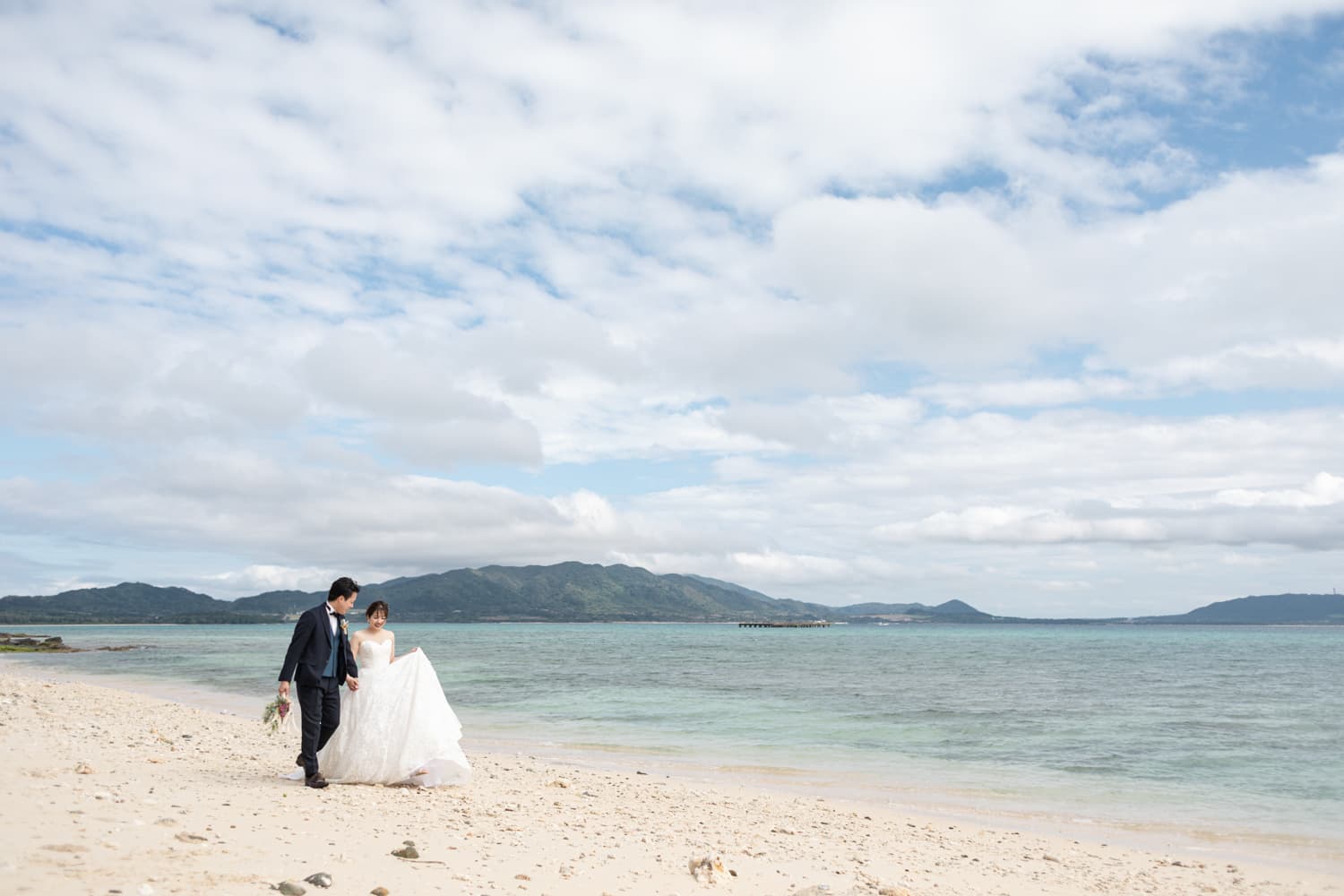 浜辺を歩く新郎新婦