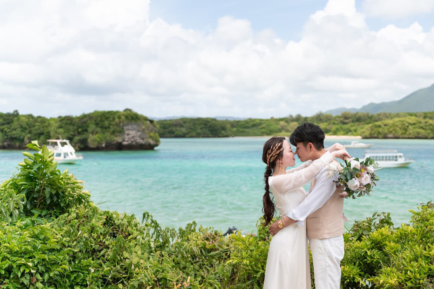 川平湾を背景に抱き合う新郎新婦