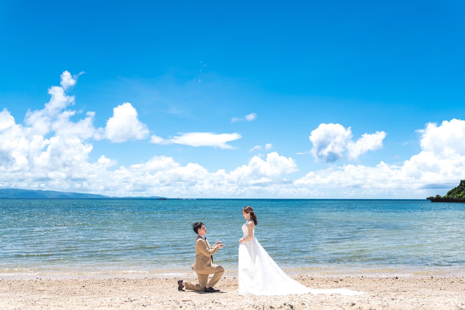 海を背景に新婦へプロポーズする新婦