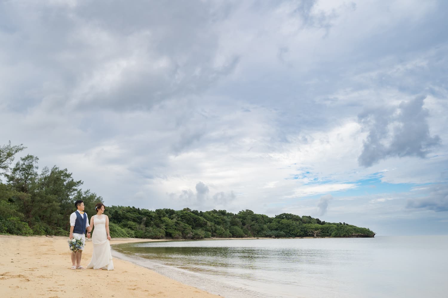 浜辺を歩く新郎新婦