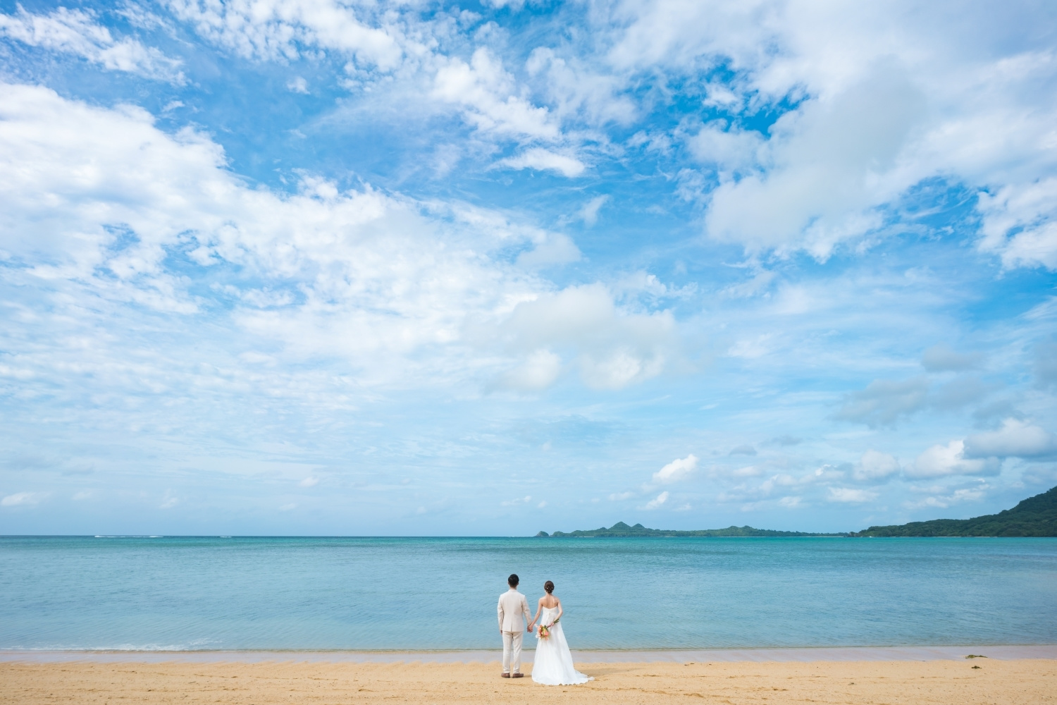 石垣島の青い海を眺める新郎新婦